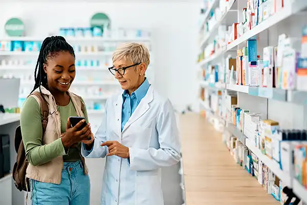 a lady and pharmacist checking medicines on mobile