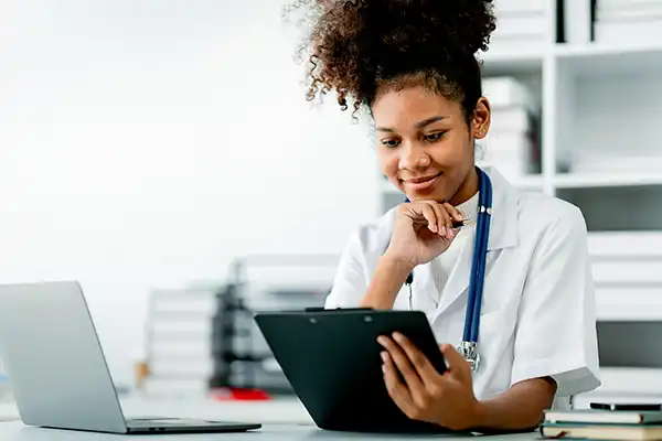 young female doctor checking electronic health records on her tablet