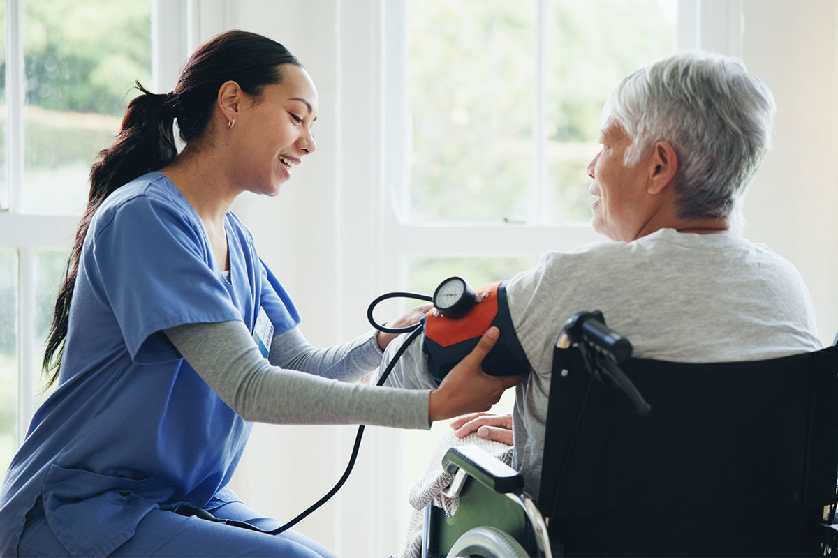 caregiver and senior in wheelchair for blood pressure