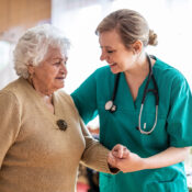 Friendly nurse supporting an elderly lady