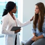 Doctor Talking To Unhappy Teenage Patient