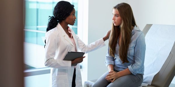Doctor Talking To Unhappy Teenage Patient