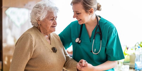 Friendly nurse supporting an elderly lady