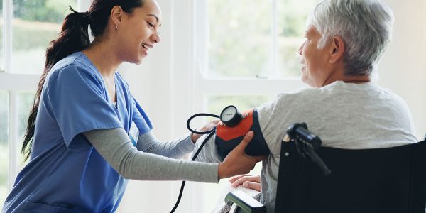 caregiver and senior in wheelchair for blood pressure