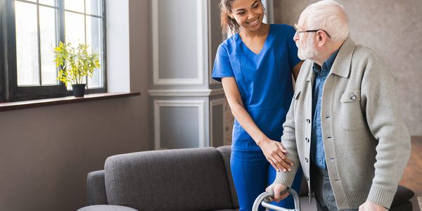 young nurse helping old elderly disable man